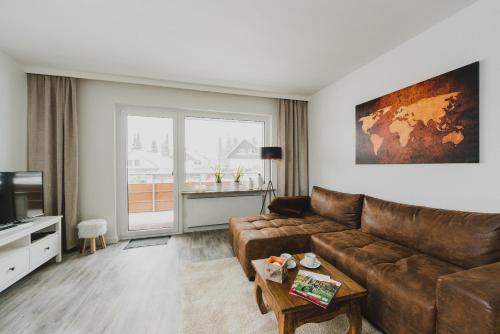 a living room with a couch and a television at Harzer Auszeit in Braunlage