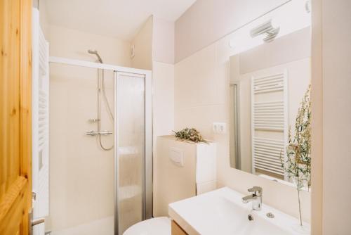 een witte badkamer met een douche en een wastafel bij Harz Zeit Braunlage in Braunlage