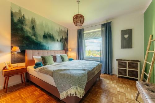 a bedroom with a bed and a large window at Hyggeglück Braunlage in Braunlage