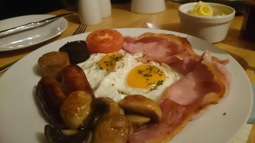 a plate of breakfast food with eggs sausage and mushrooms at Ocean Heights B&B in Lissadell