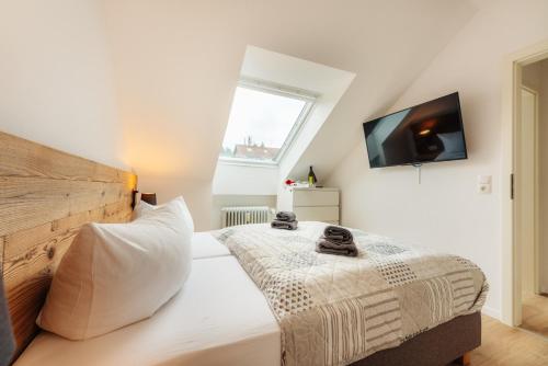 um quarto com uma cama e uma televisão na parede em Jederzeit em Sankt Andreasberg
