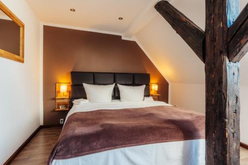 - une chambre mansardée avec un grand lit dans l'établissement Fichtenblick, à Sankt-Andreasberg