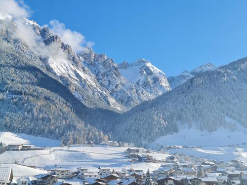 a town in the snow with mountains in the background at klein&fein in Neustift im Stubaital
