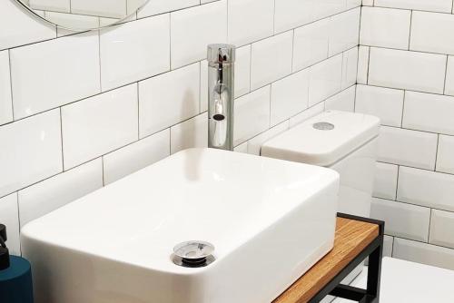uma casa de banho branca com um lavatório e um WC em Ultreia , piso turístico termal em Ourense