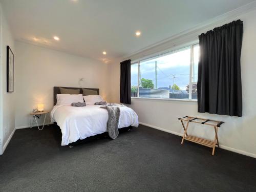 1 dormitorio con cama y ventana grande en Central Villa, Close to everything! By KOSH BNB en Hamilton