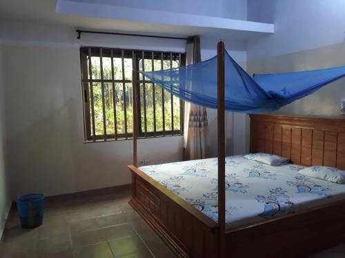 a bedroom with a bed with a blue canopy at Villa ETE-D in Bohicon