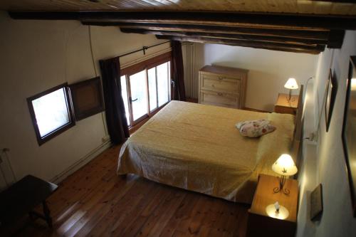 sypialnia z dużym łóżkiem i oknem w obiekcie Cal Bové w mieście Sant Guim de Freixenet