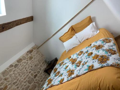 1 dormitorio con cama con edredón y almohada en F3 avec Jardin, Calme, Fôret, Barbizon, en Chailly-en-Bière
