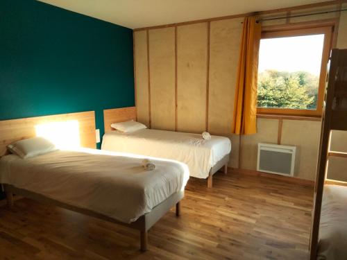 a room with two beds and a window at A la belle étoile in Mellionnec