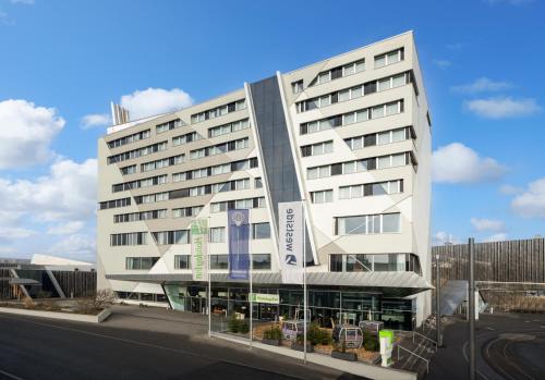 Un bâtiment blanc avec un panneau. dans l'établissement Holiday Inn Bern Westside, an IHG Hotel, à Berne