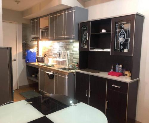 a kitchen with brown cabinets and a counter top at 2 Bedroom Condo Unit in Manila