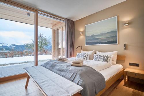 a bedroom with a large bed and a large window at HILL - 73 by AA Holiday Homes in Tauplitz