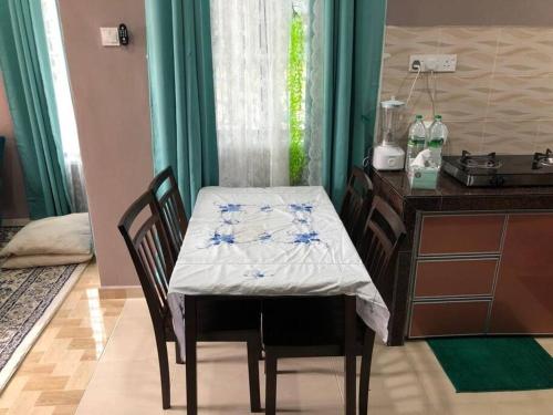 een tafel en stoelen met een tafel en een bureau bij Whole house - 2 bedrooms for family with kids and Free Wifi in Changlun