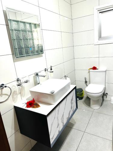 a white bathroom with a sink and a toilet at 88 Days Self Catering Holidays & Accomodation in Baie Lazare Mahé