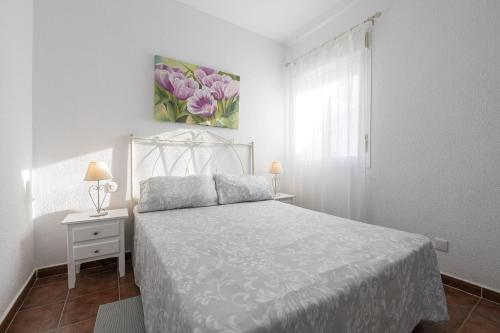 Habitación blanca con cama y ventana en Brisa Marina, en Chiclana de la Frontera