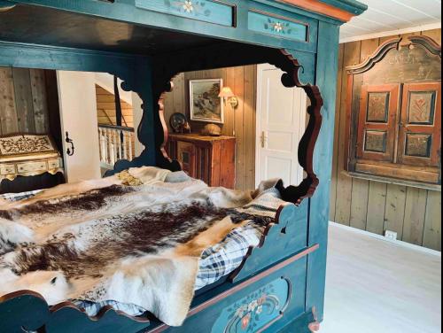 a bed in a room with a blue bed frame at Traditional timber farm with Sauna & Wi-Fi in Baukål