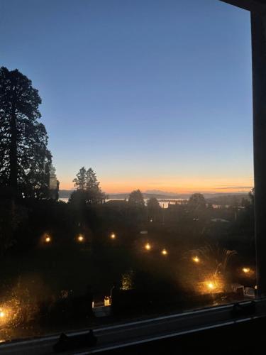 a view from a window of a city at night at Moorlands in Helensburgh