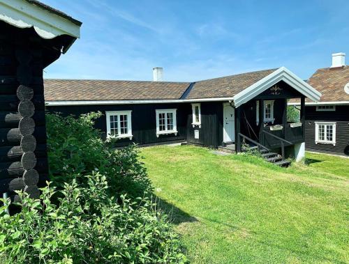 uma casa preta com um quintal em frente em Traditional timber farm with Sauna & Wi-Fi 
