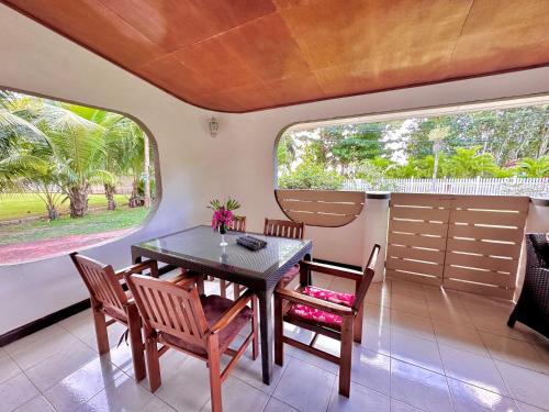 d'une salle à manger avec une table, des chaises et une fenêtre. dans l'établissement 88 Days Self Catering Holidays & Accomodation, à Baie Lazare