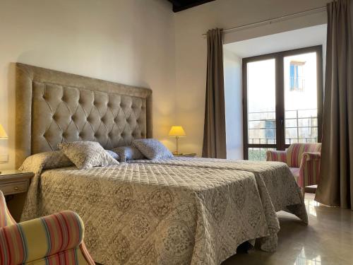 a bedroom with a large bed with a large window at Apartamentos Casa-Palacio Santa Pola in Ronda