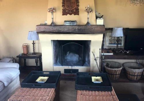 a living room with a fireplace with two tables at La Casa Rota Arahuetes in Arahuetes