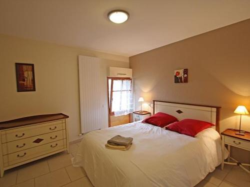 una camera da letto con un grande letto bianco con cuscini rossi di Gîte moderne à Rebeuville, proche Neufchâteau, 3 ch., accès PMR, pêche, WIFI, tout inclus - FR-1-589-157 a Rebeuville