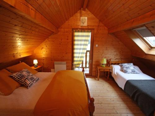 a bedroom with two beds in a wooden cabin at Charmant Chalet Vosgien – Idéal Couple/Curistes – Calme et Nature – Proche Plombières-les-Bains - FR-1-589-230 in Le Val-dʼAjol