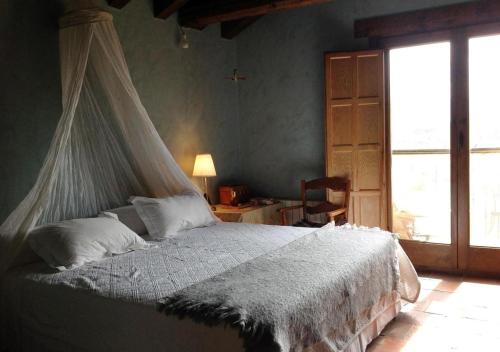 a bedroom with a bed with a mosquito net at La Casa Rota Arahuetes in Arahuetes