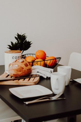 a table with a basket of fruit and bread on it at Cosy and modern apartment closed to the ski lift in Crans-Montana