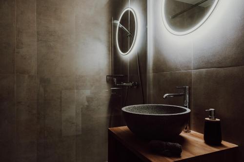 a bathroom with a bowl sink and a mirror at Cosy and modern apartment closed to the ski lift in Crans-Montana