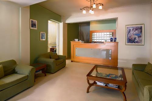 a living room with two couches and a flat screen tv at Hotel Fotini in Kalamata