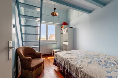 une chambre avec un lit, une chaise et une fenêtre dans l'établissement Villa tout confort pour 10 - 850 m de la plage, à Les Sables-dʼOlonne
