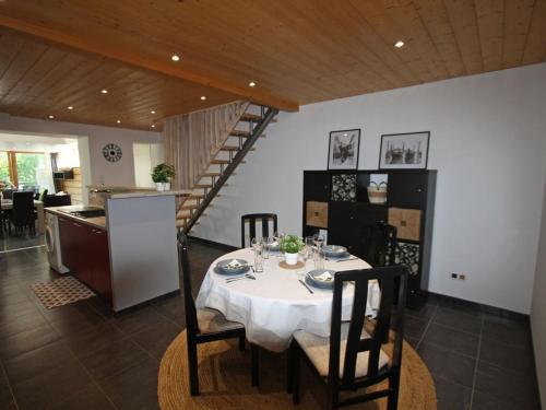 une salle à manger avec une table et une cuisine dans l'établissement Gîte chaleureux avec terrasse, proche sentiers de randonnée, équipements inclus, à 30min de Saint-Dié - FR-1-589-381, à Le Saulcy