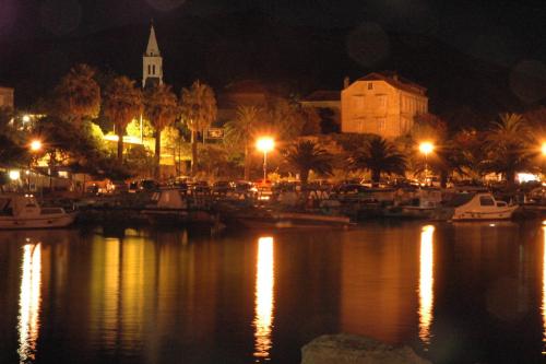 a harbor at night with boats in the water at Lulak Studio Apartments in Orebić