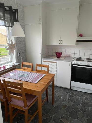 uma cozinha com uma mesa, cadeiras e um fogão em Lövåsen em Glava