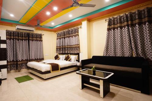 a bedroom with a bed and a couch at Tirupati Lodge NJP in Siliguri