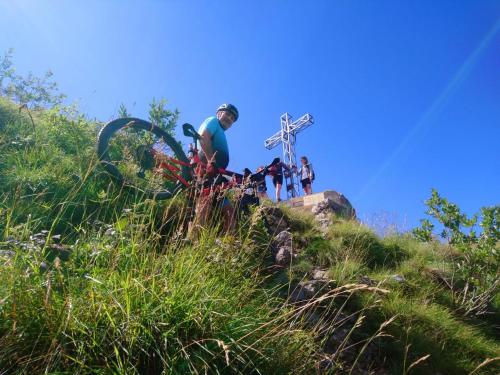 a group of people standing on a hill with a cross at Casa Luca e Cristina in Mezzolago