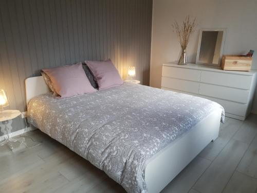 1 dormitorio con 1 cama grande y 2 almohadas rosas en Ô Valanvron - Appartement dans une ancienne ferme neuchâteloise, en La Chaux-de-Fonds