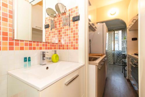 uma pequena cozinha com um lavatório e um espelho em San Salvario Stylish Apartment em Turim