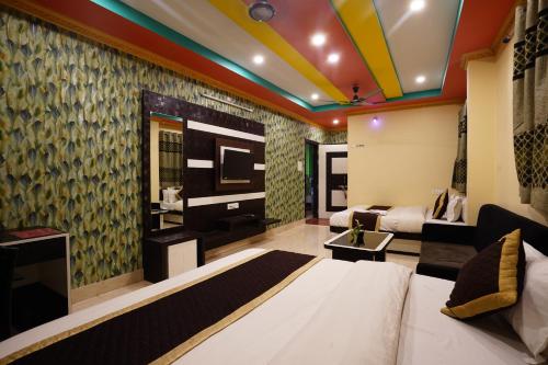 a hotel room with a bed and a couch at Tirupati Lodge NJP in Siliguri