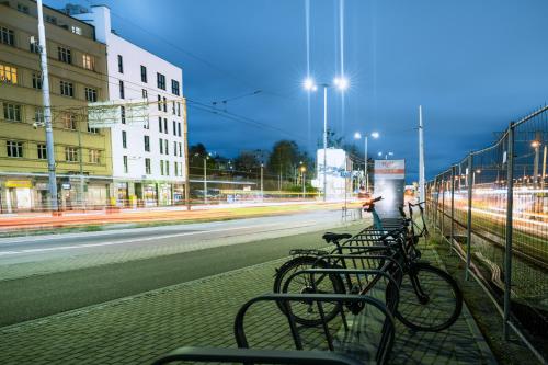 a row of bikes parked next to a street at night at Apartamenty Przystanek Morska in Gdynia
