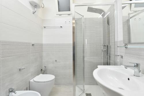 Baño blanco con aseo y lavamanos en Casa Vacanza LaLu LeLo, en Castellabate