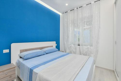 Un dormitorio azul con una cama blanca y una ventana en Casa Vacanza LaLu LeLo, en Castellabate