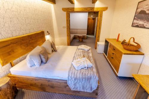 1 dormitorio con cama grande de madera y vestidor en Hotel Strachanovka - Jánska Koliba, en Liptovský Ján