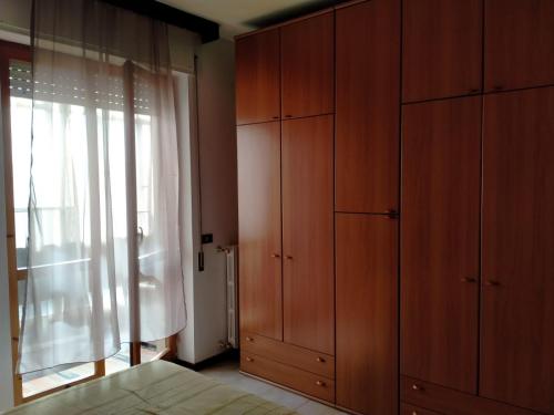 - une chambre avec des placards en bois et une grande fenêtre dans l'établissement La casedda di Zietta, à Aggius