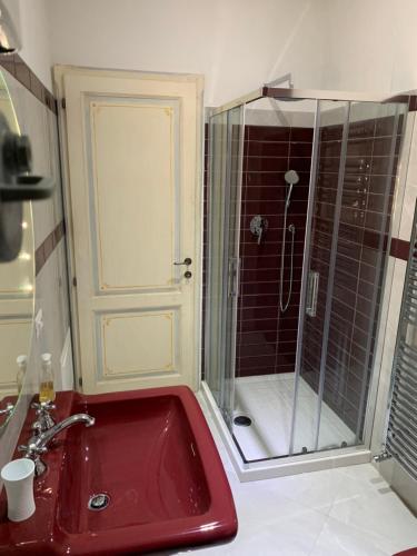 y baño con lavabo rojo y ducha. en Villa Paglicci Reattelli Agriturismo en Castiglion Fiorentino