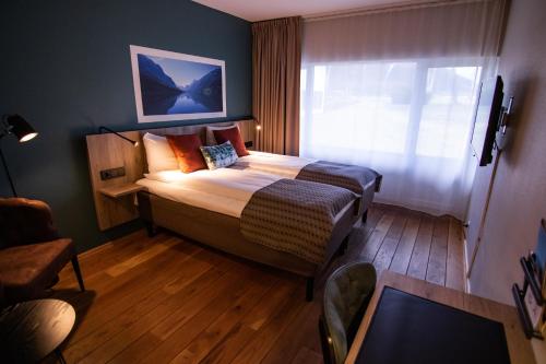 a bedroom with a large bed in a room with a window at Nordfjord Hotell in Nordfjordeid