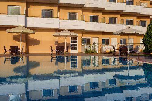 a hotel with a swimming pool with chairs and umbrellas at Hotel Fotini in Kalamata