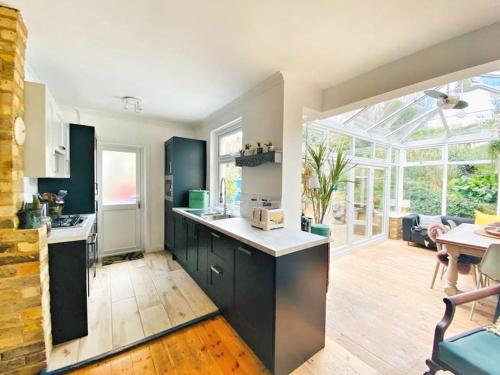 a kitchen with a large window and a dining room at Home away from Home - Broadstairs beautiful family seaside house with garden and parking in Kent