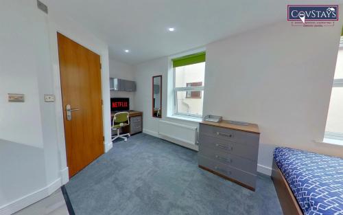 a bedroom with a bed and a desk and a window at Victoria House - Deluxe Studios in Coventry City Centre, free parking, by COVSTAYS in Coventry